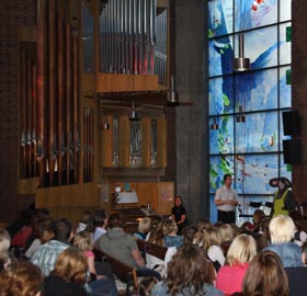 Kindern wird im Kirchengebäude die Orgel erklärt